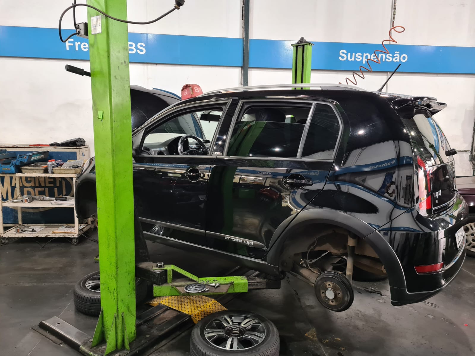 Carro no elevador sendo desmontado