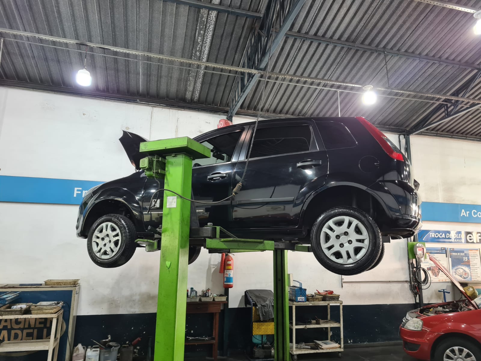 Carro no elevador sendo desmontado