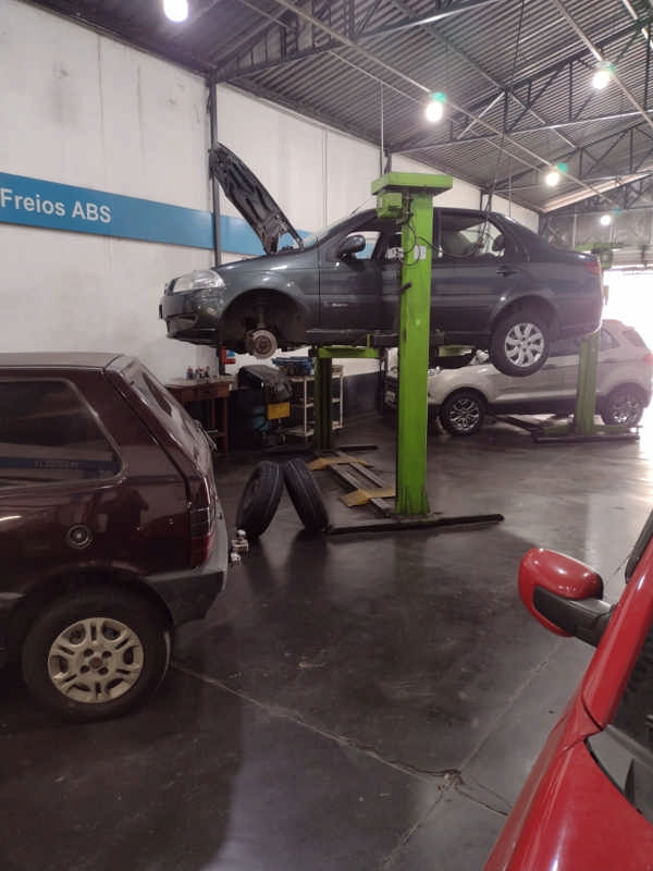 Carro no elevador, sendo desmontado.